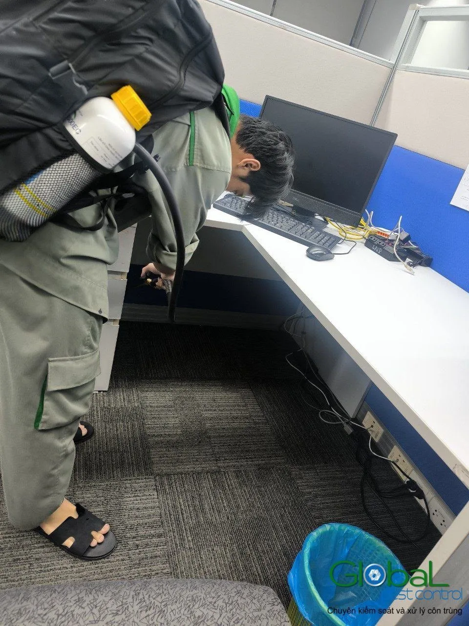 A technician treating under office desks