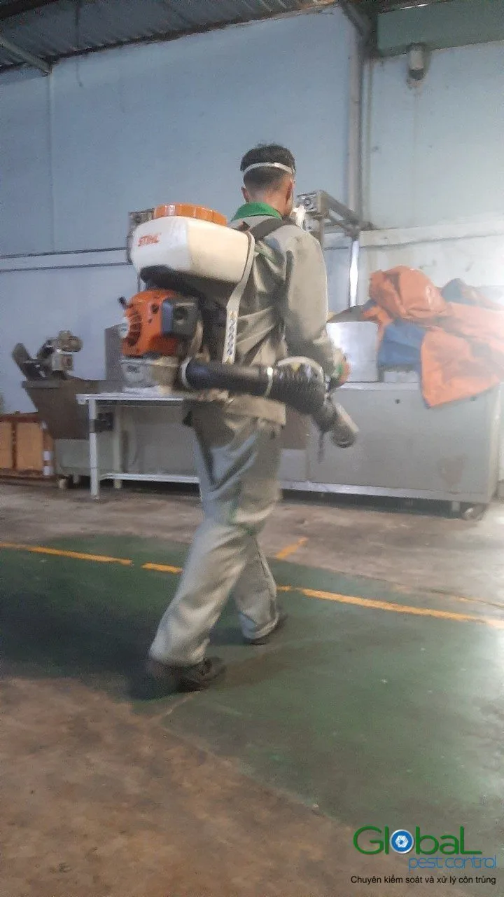 A technician treating a walkway in a production workshop