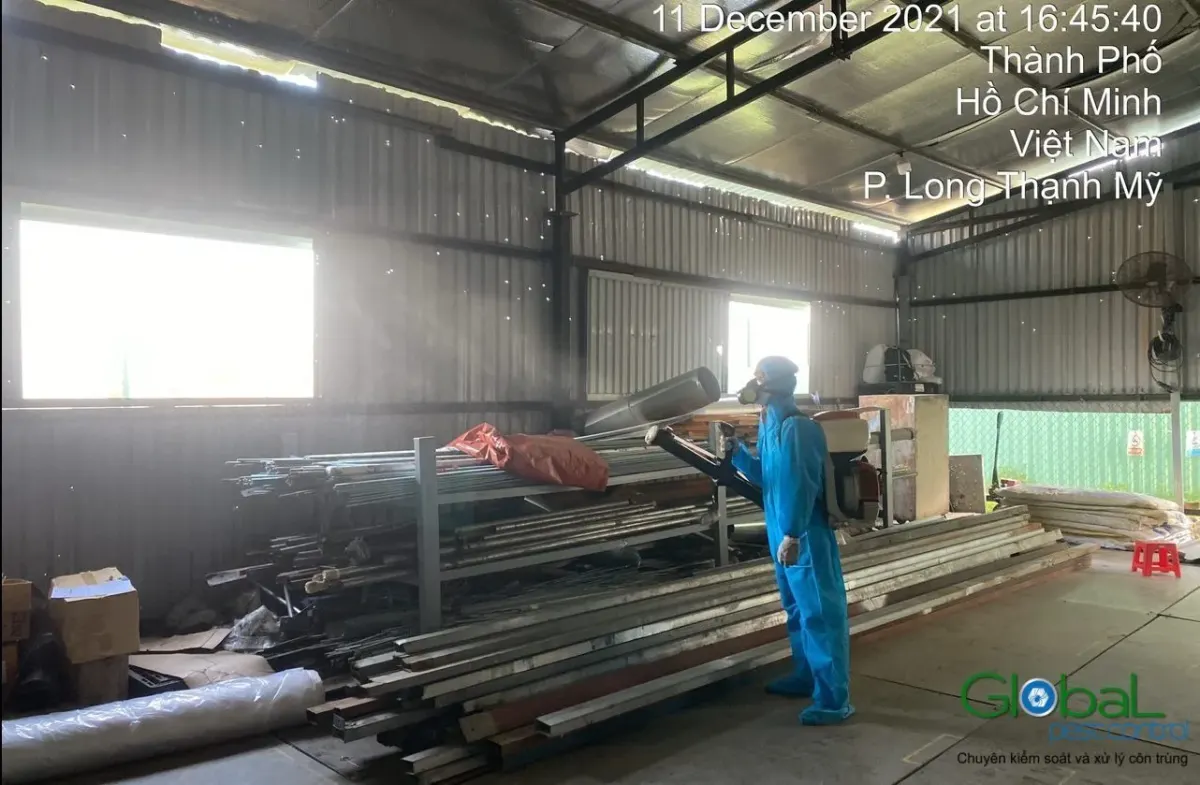 A technician treating a materials store with a metal roof