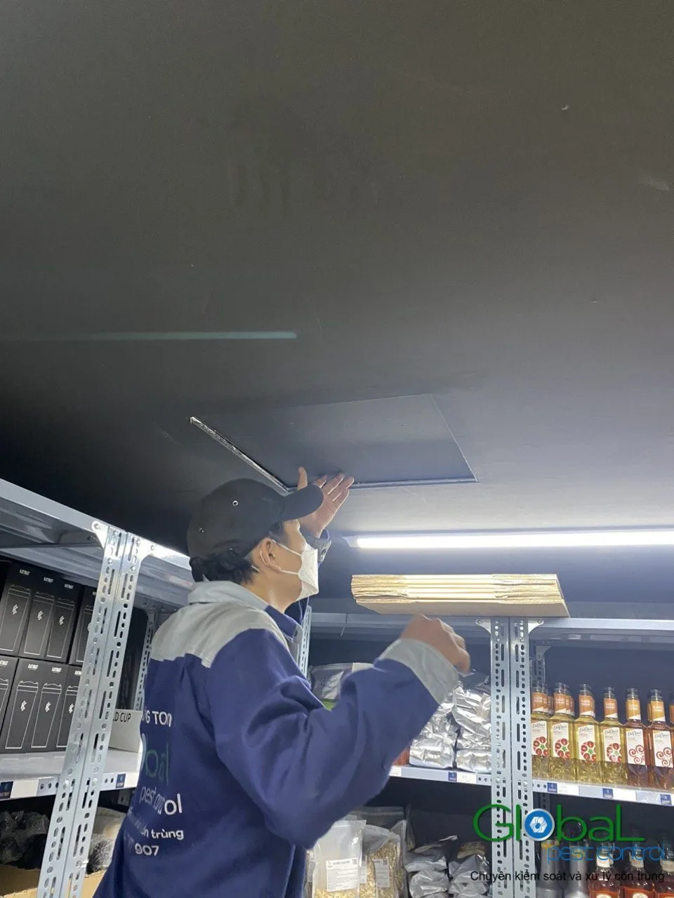 A technician treating product display shelves in a shop
