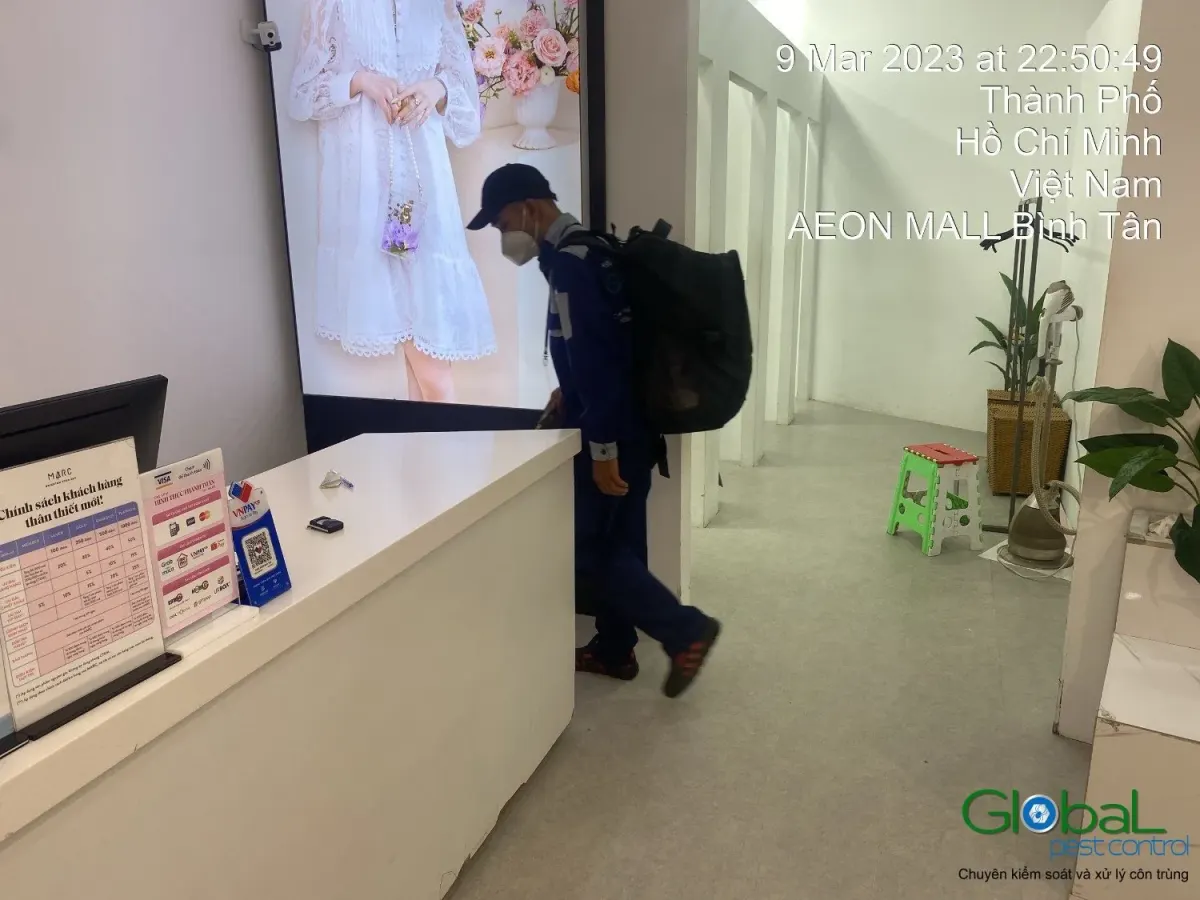 A technician treating the checkout counter of a shop in a mall
