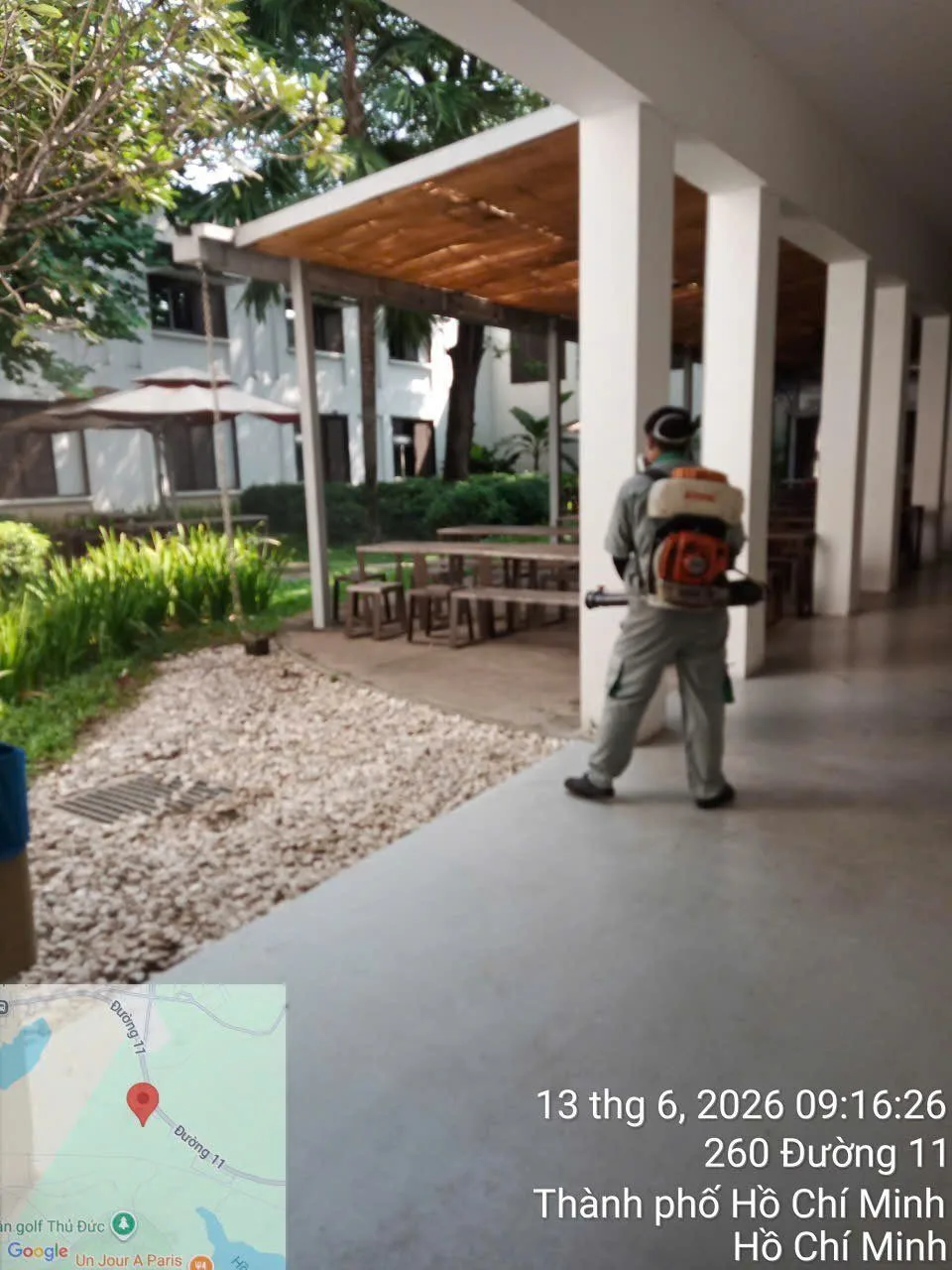 A technician treating a covered walkway in a school yard