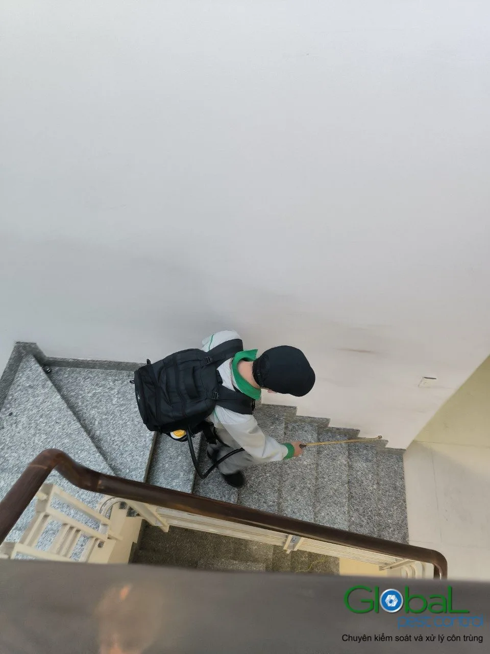 A technician treating along the stairs of a townhouse