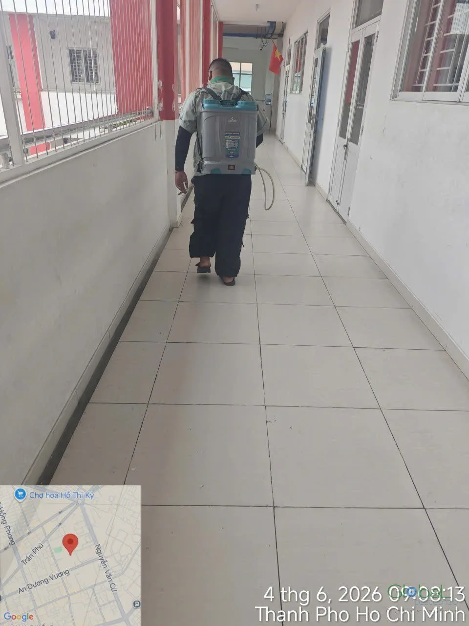 A technician treating a long classroom corridor