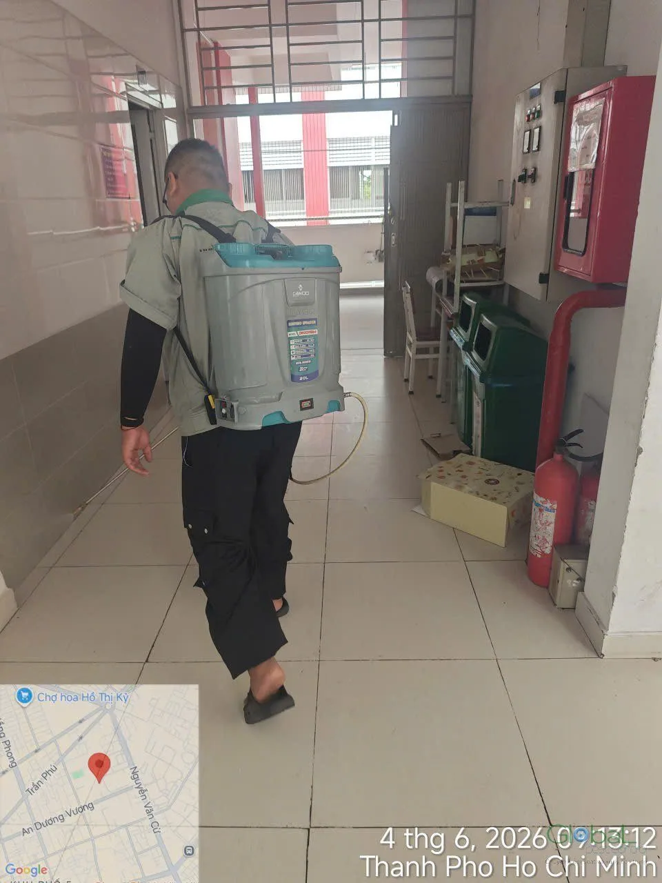 A technician treating by a fire cabinet in a school corridor