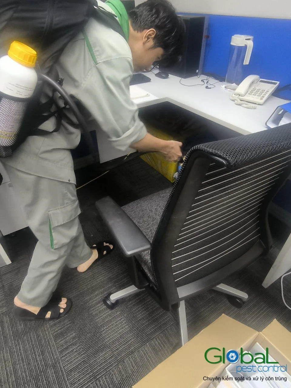 A technician treating under office desks