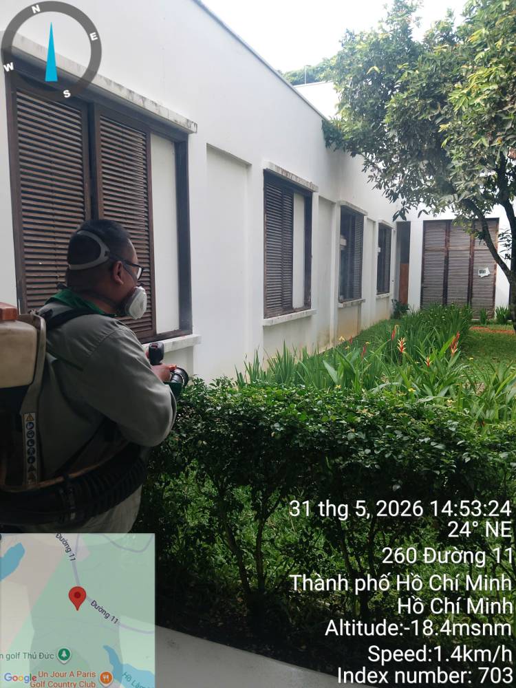 A technician treating hedges, paths and covered areas across a school campus