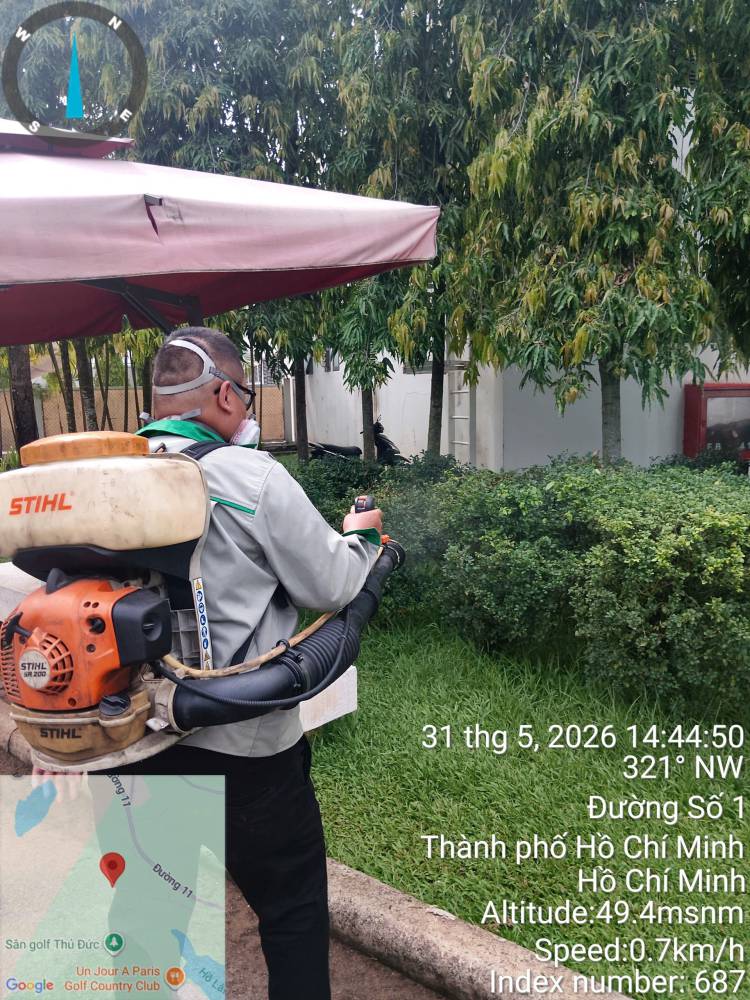 A technician treating hedges, paths and covered areas across a school campus