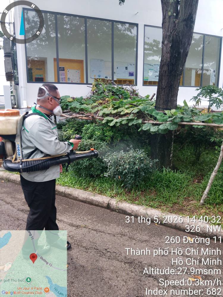 A technician treating hedges, paths and covered areas across a school campus
