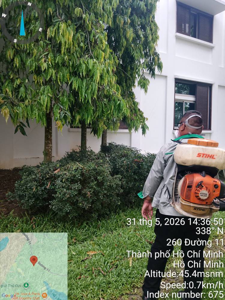 A technician treating a lawn edge and the drain cover set into it