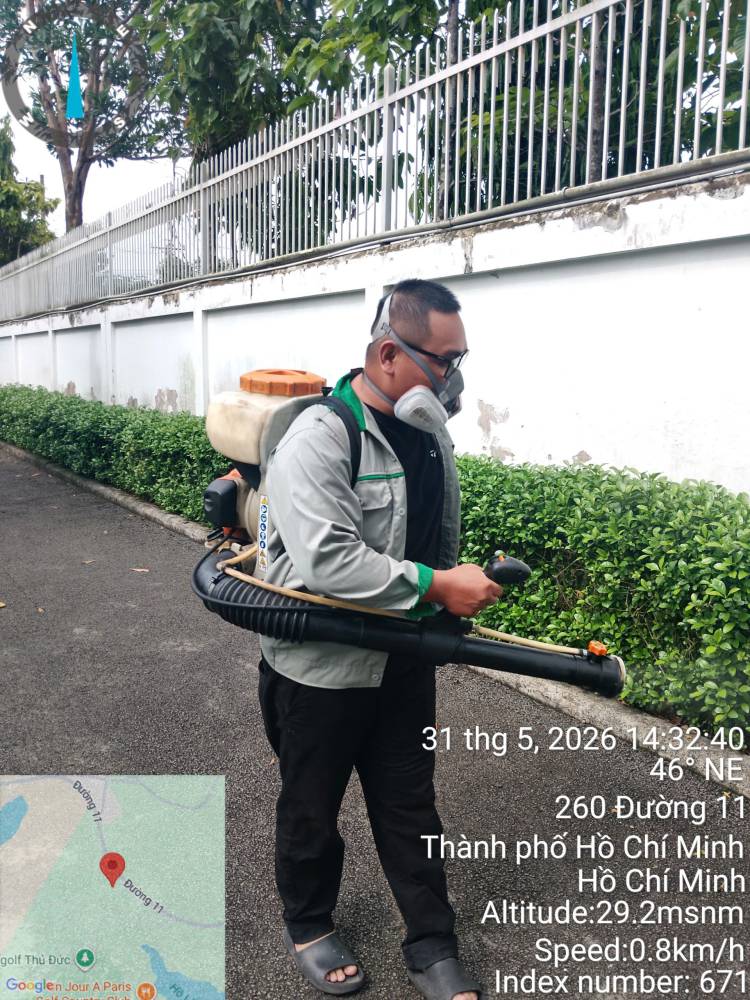 A technician treating a lawn edge and the drain cover set into it