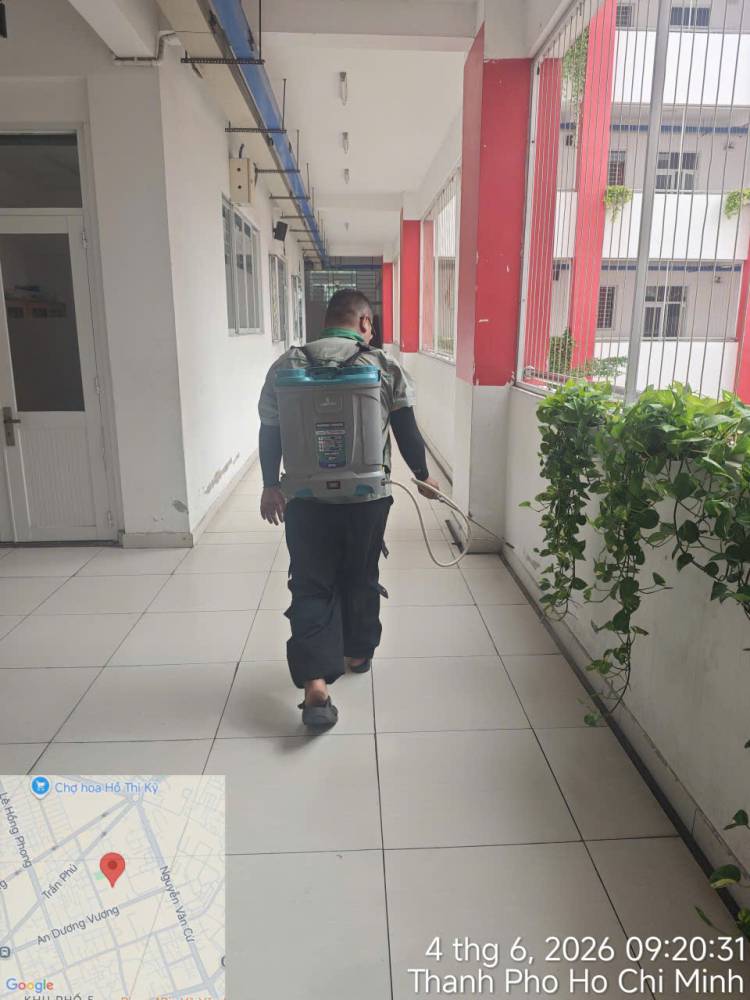 A technician treating corridors, stairs and storage areas inside a school