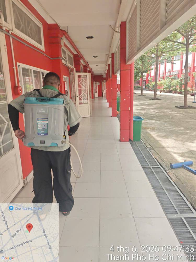 A technician treating corridors, stairs and storage areas inside a school