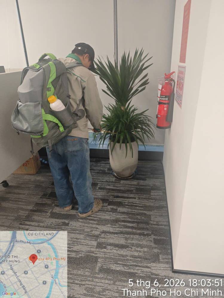 A technician treating indoor planters and pantry areas in an office