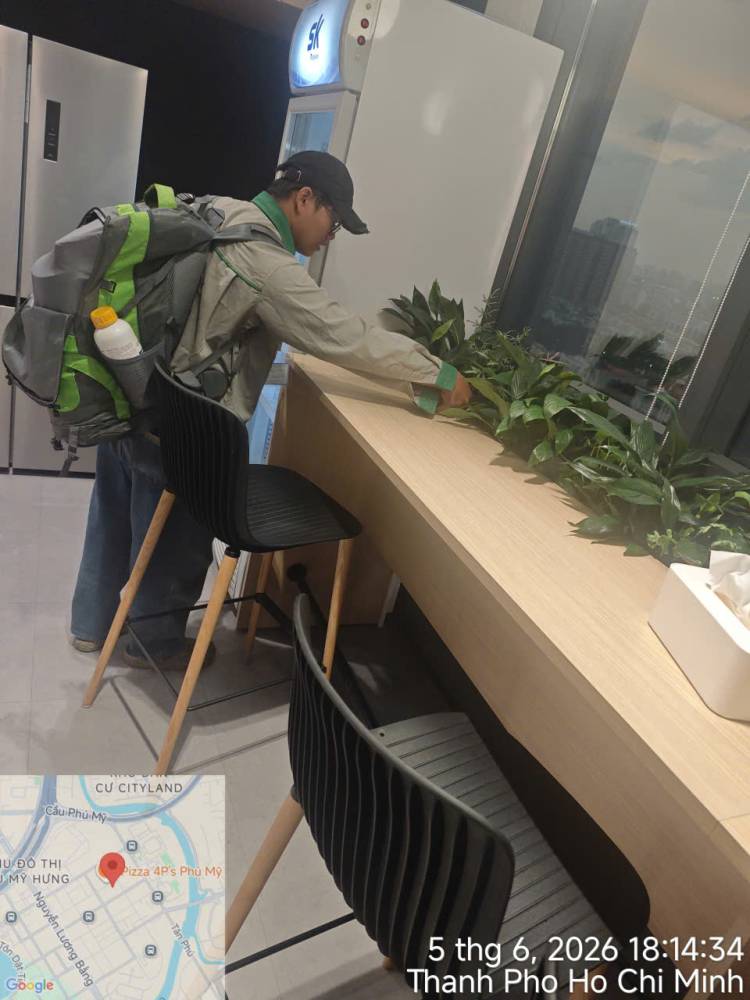 A technician treating indoor planters and pantry areas in an office