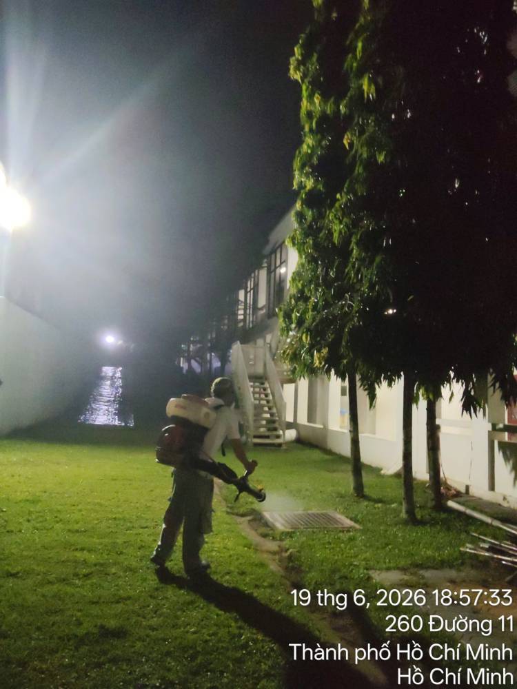 A technician treating lawns, hedges and walkways across a campus