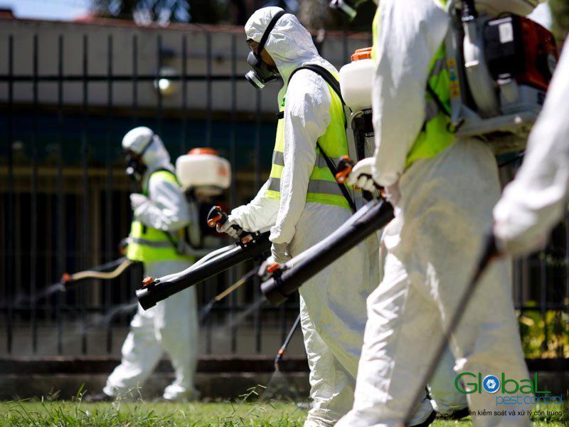 A Global Pest Control team fogging an outdoor area in full protective equipment